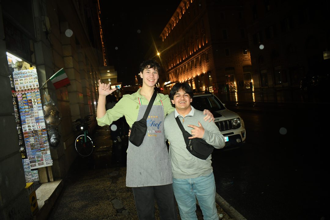 Ayden and PB smiling together on a city street at night.